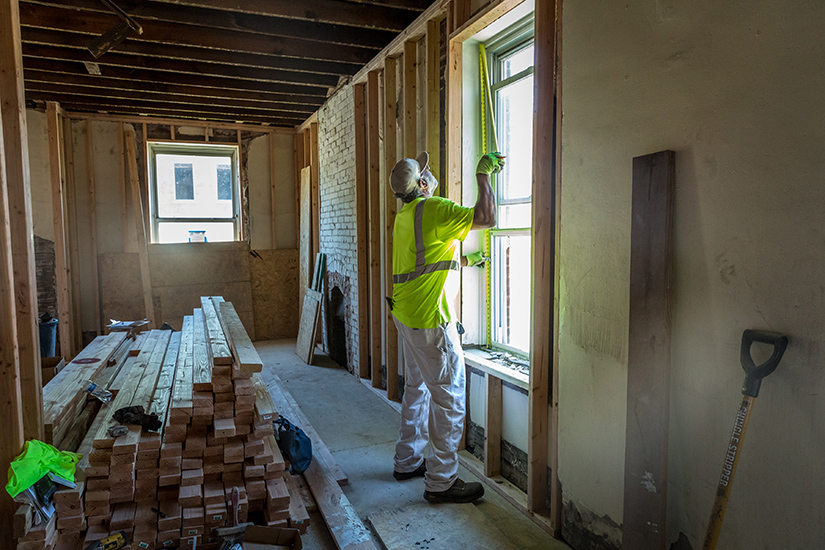 Tony Miller measured the inside of a window frame as St. Joseph Housing Initiative renovates a home in St. Louis on June 11. The initiative rehabs homes to produce quality housing for low- and moderate-income families in the St. Louis area.