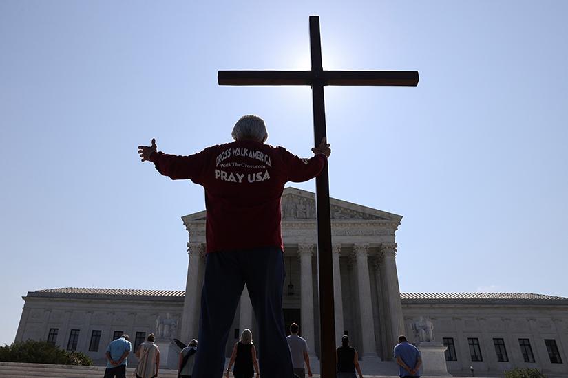A demonstrator in Washington held a large cross outside the U.S. Supreme Court July 8.