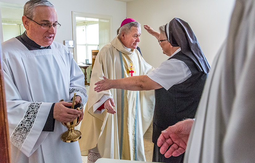 Sister Sue Ann Hall reached out for a hug to thank Archbishop Robert J. Carlson after he celebrated a Mass and blessing of Our Lady of Guadalupe Convent in 2017, set up to be a place of prayer and hospitality near Planned Parenthood.