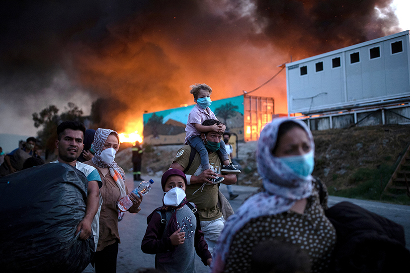 Displaced people fled after fires broke out at the Moria refugee camp on the island of Lesbos, Greece, Sept. 9. The camp, which was mostly destroyed, was home to at least 12,000 people, six times its maximum capacity of just over 2,000 asylum-seekers.