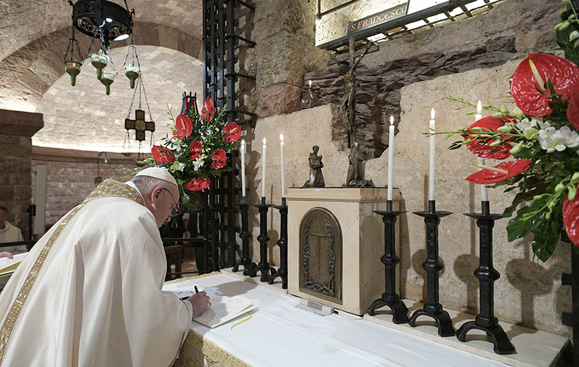 Pope Francis signed his new encyclical, "Fratelli Tutti, on Fraternity and Social Friendship" after celebrating Mass at the Basilica of St. Francis in Assisi, Italy, Oct. 3.