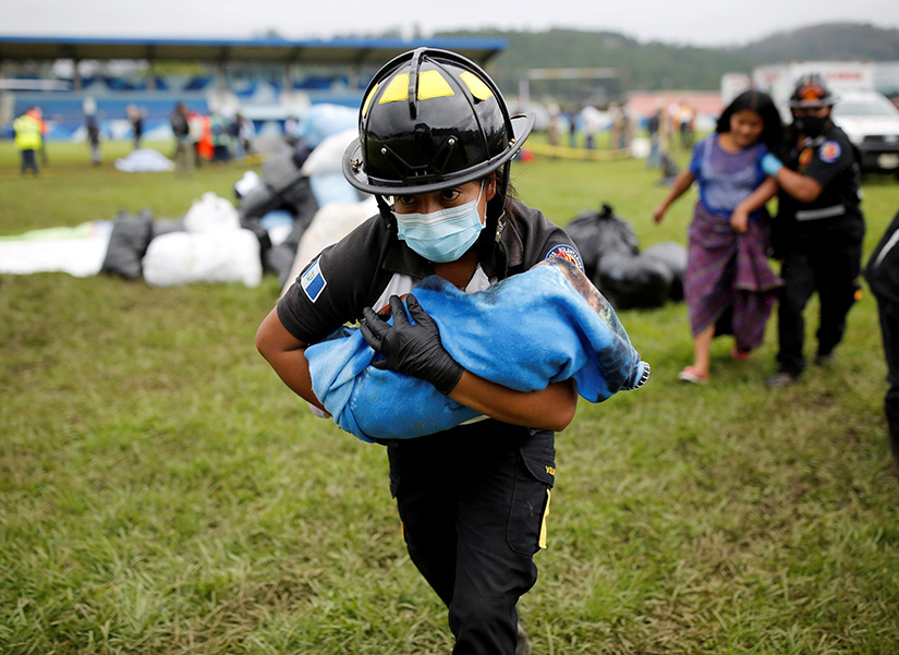 A firefighter carries a baby rescued along with her mother from an area affected by mudslides in San Cristobal Verapaz, Guatemala, Nov. 7. The landslides were caused by the rains from Hurricane Eta.