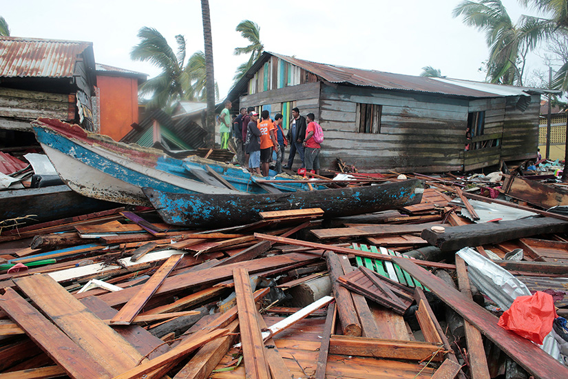 Residents stood amid debris outside homes in Puerto Cabezas, Nicaragua, Nov. 17 in the aftermath of Hurricane Iota. The Category 4 storm hit the coast of Nicaragua near the border of Honduras Nov. 16, causing storm surges and flooding and further damaging buildings already wrecked by Hurricane Eta.