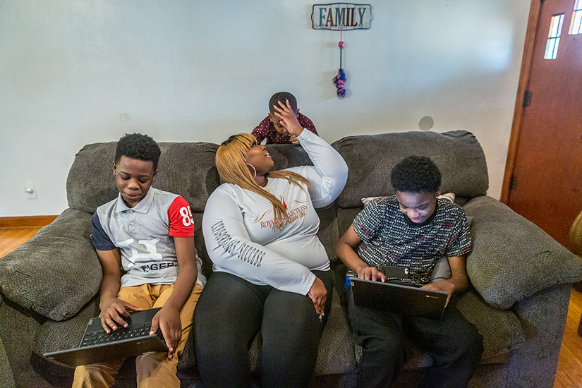 Dawn Cotton has been assisted several times by Catholic Charities federated agencies. She helped her sons Drentay and Dontay Smith with their schoolwork while son Ace Rimson sought her attention at their St. Louis home.