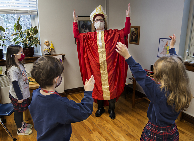 Karen Jaeger dressed up as St. Nicholas to teach students at Sacred Heart Villa School about the real St. Nicholas and the symbolism of the candy cane on Dec. 4. From left are 5-year-old students Winifred Frisch, Thomas McCabe and Dervla Sheehan.