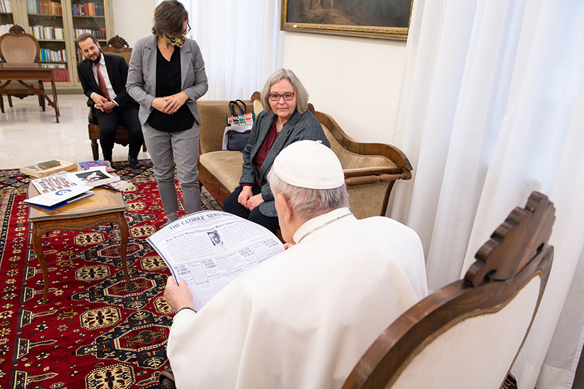 Pope Francis looked at a copy of the April 11, 1920, edition of the “Catholic News Sheet,” during a meeting with members of the Catholic News Service Rome bureau at the Vatican Feb. 1. The special audience was in recognition of the 100th anniversary of CNS. Pictured are CNS staffers Robert Duncan, Carol Glatz and Cindy Wooden.