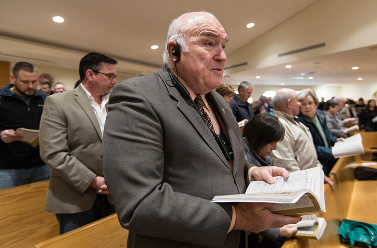 Robert Noonan used a hearing assist device April 8 at Mass at St. Patrick Church in Wentzville. In December, the parish installed a system that includes a radio transmitter to broadcast the church’s sound system to people who need assistance hearing.