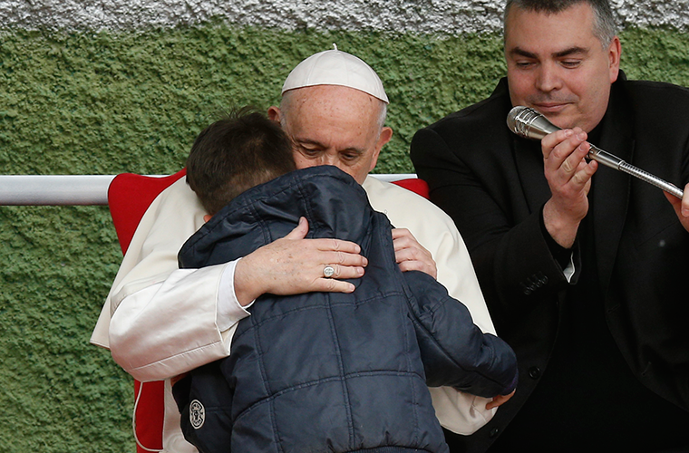 Pope Francis embraced Emanuele, a boy whose father died, as he visited St. Paul of the Cross Parish in Rome April 15. Emanuele hesitated to ask his question, but the pope encouraged him to speak privately to the pope, who then shared his question.