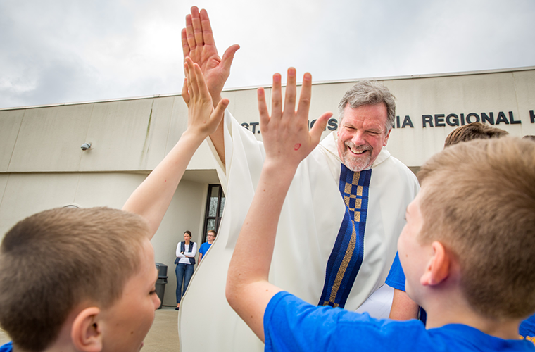 Father Kevin Schmittgens, president at St. Francis Borgia Regional High School, greeted visitors from Catholic schools April 24. Archbishop Robert J. Carlson celebrated Mass at the high school, which invited students from area Catholic grade schools.