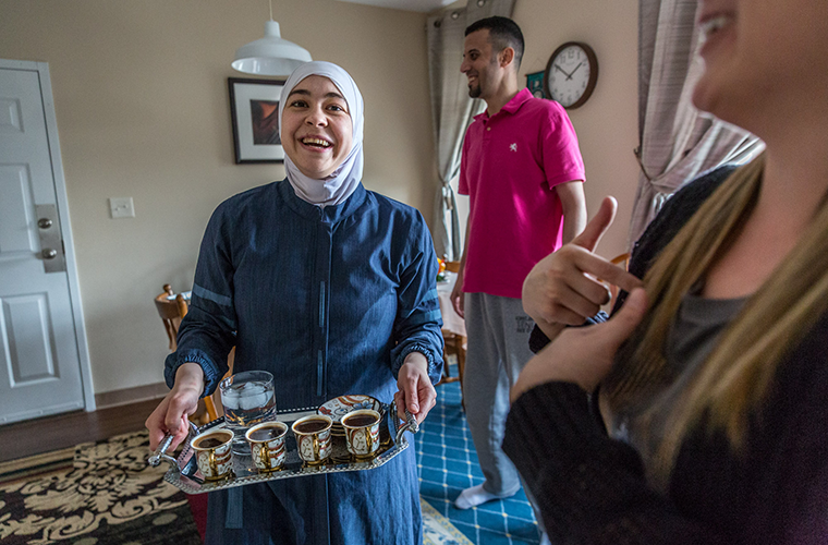 Lina Almuallem brought in a tray of coffee as she talked with Jessica Bueler on the day she was preparing homemade Syrian cuisine in her kitchen in Mapelwood on April 22.