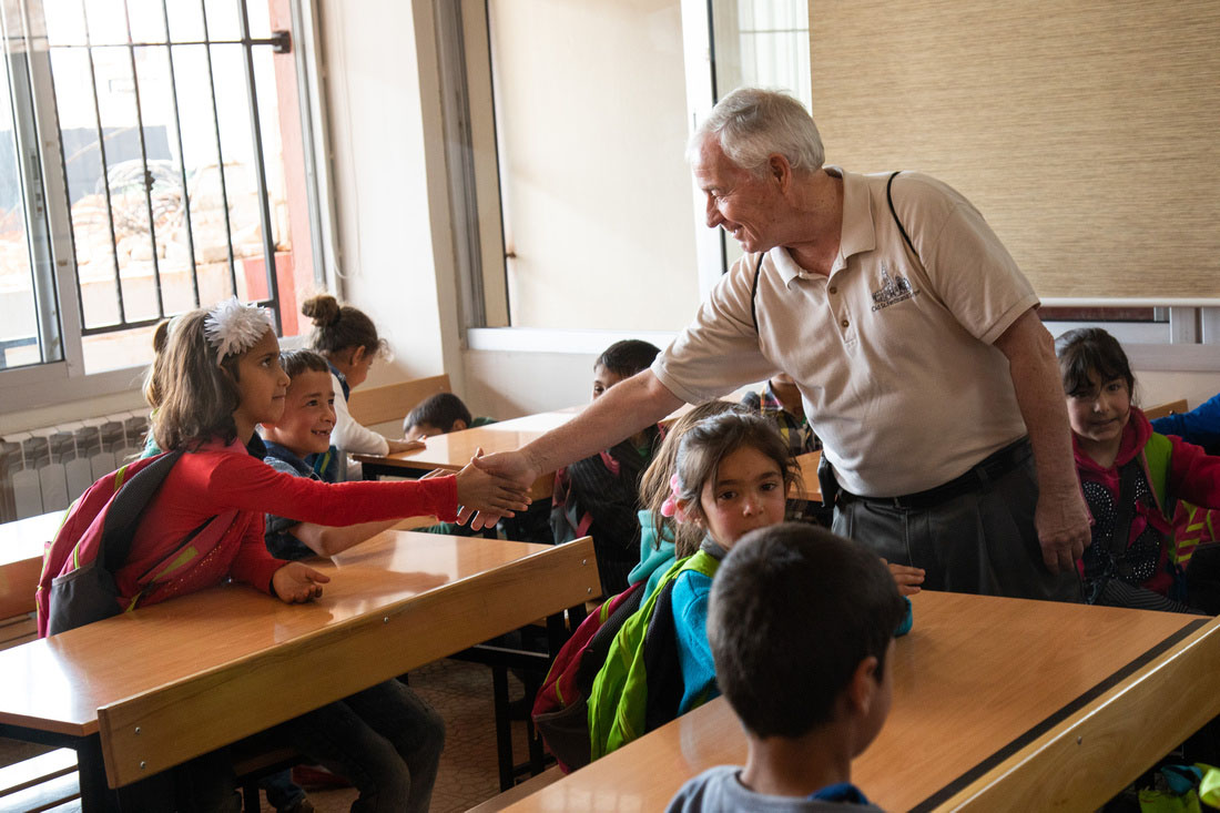Msgr. Jack Schuler, chaplain at Catholic Charities of St. Louis and pastor of St. Cronan Parish in south St. Louis, greeted students at a class in Lebanon. The school serving refugee children is supported by Catholic Relief Services, the overseas relief and development agency of the U.S. bishops.