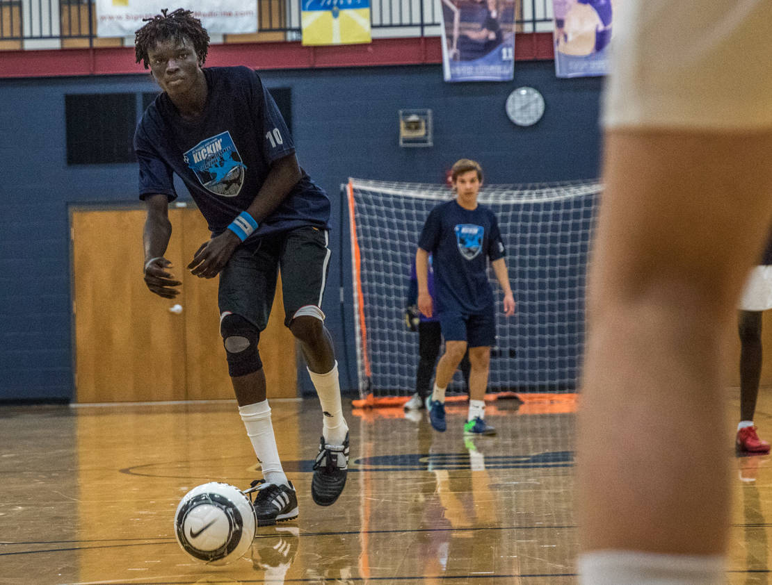 St. Louis Roadies player Chuong Tang, a refugee from South Sudan, kicked the ball during a game against St. Dominic High School soccer players. The St. Louis Roadies, a team comprised of homeless or formerly homeless men and refugees, played against a team from St. Dominic as part of a school project by student Tony Petruso.