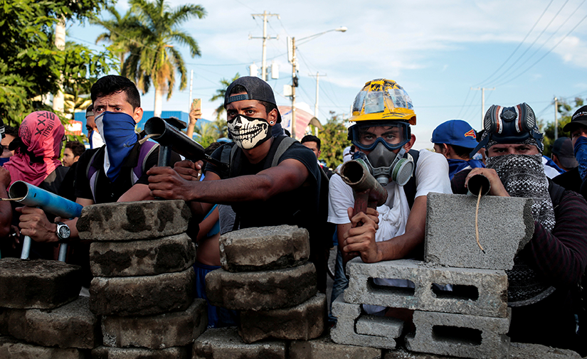 Demonstrators in Managua, Nicaragua, stood behind a barricade during clashes with police May 30. Nicaragua’s bishops issued an urgent statement May 31 calling for an end to police and paramilitary attacks on protesters.