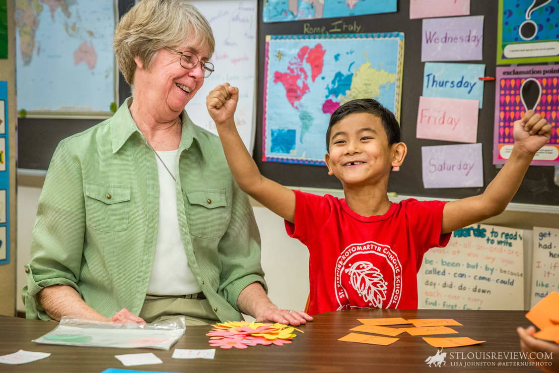 Sister Joan Stoverink, ASC, smiled as kindergarten student David Mung celebrated a victory in a game of “Go Fish Antonym” in class on May 21. Sister Joan tutors students at St. Stephen Protomartyr, many of whom are from Myanmar, as part of the English Tutoring Project.