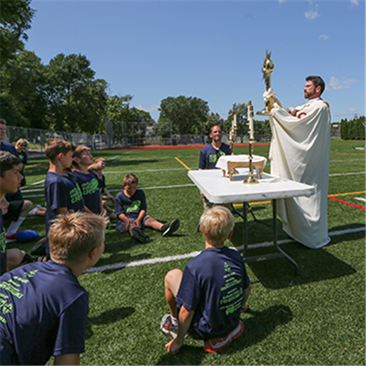 Summer camp combined football drills, scrimmages with Mass, adoration