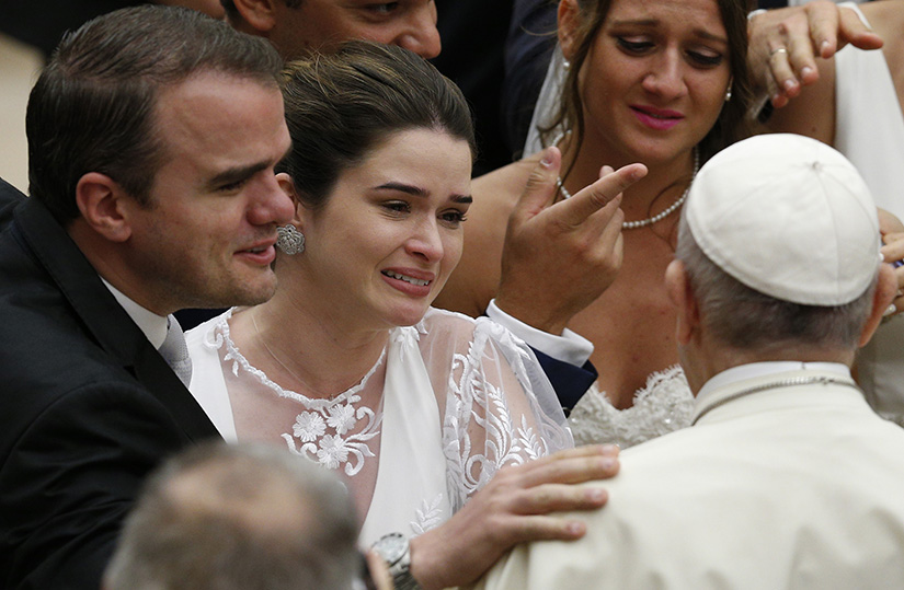 Pope Francis greeted a newly married couple at his general audience in Paul VI hall at the Vatican Aug. 22.