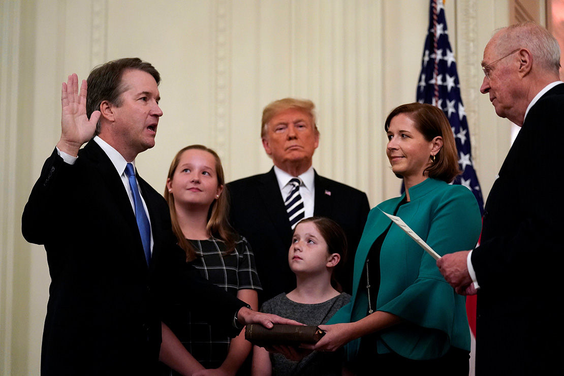 U.S. Supreme Court Justice Brett Kavanaugh placed his hand on a Bible during his Oct. 8 public swearing-in ceremony with retired Justice Anthony Kennedy in the East Room of the White House in Washington. Also pictured are President Donald Trump and Kavanaugh’s wife, Ashley, and daughters, Liza and Margaret.