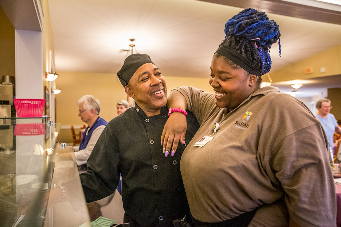 AMVETS Post Commander Fred Johnson talked with fellow employee Ashley Sewell as residents gathered for their evening meal at Naomi House on Oct. 15.