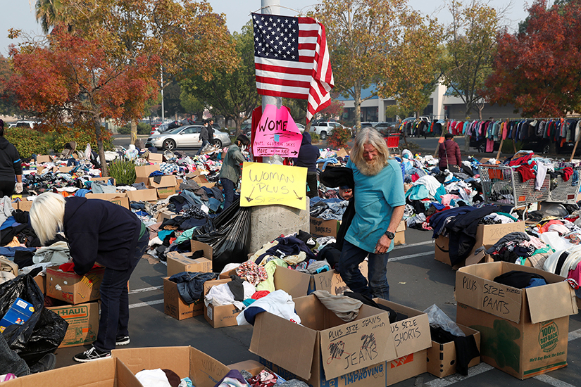 People looked through clothes at a donation site for victims of the Camp Fire in Chico, Calif., Nov. 18. More than 75 people have died in the fire, with almost 1,000 still missing.