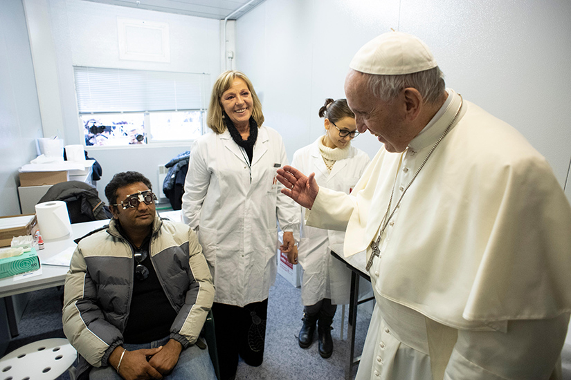 Pope Francis greeted a man at a surprise visit to a free health clinic for the needy in St. Peter’s Square at the Vatican Nov. 16. The clinic was open for a week in advance of the Nov. 18 observance of World Day of the Poor.