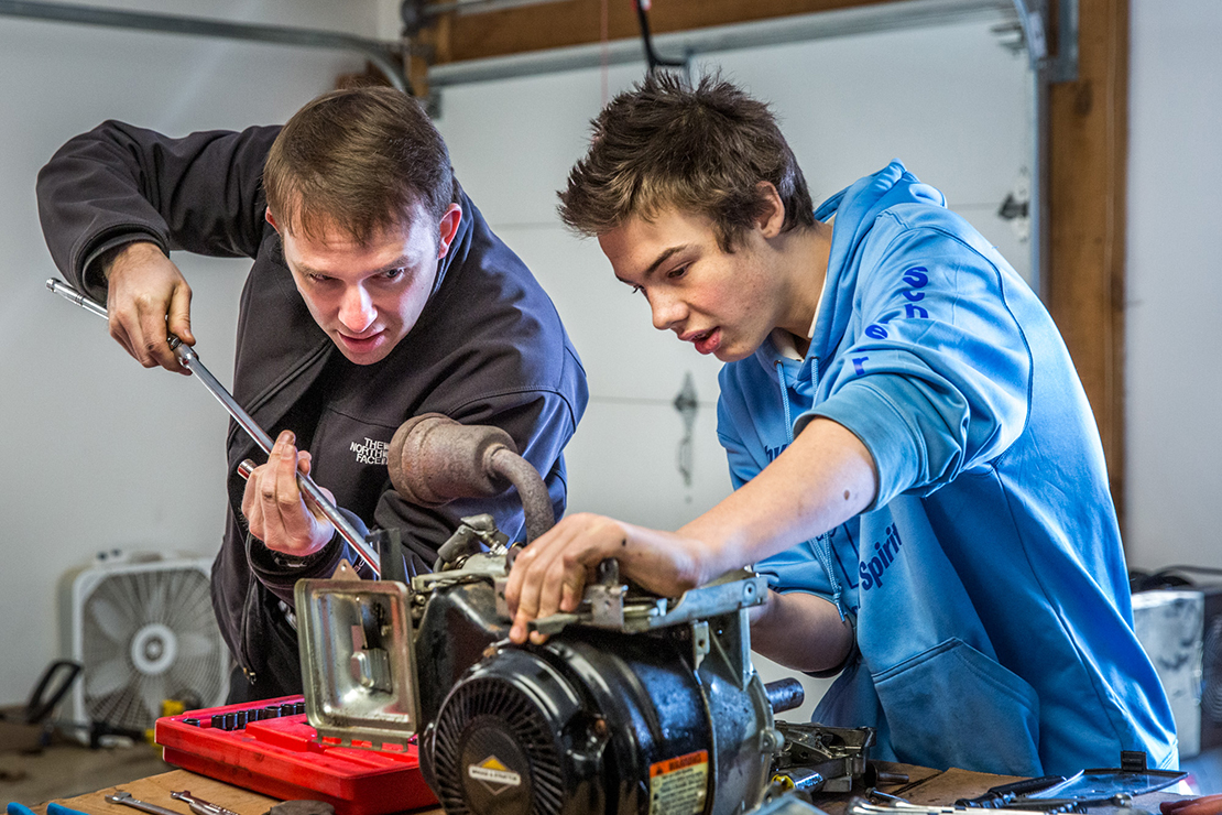 Father Kevin Schroeder, left, and eighth-grader Caleb Schellenberg dismantled the engine of a broken power washer at Incarnate Word School in Chesterfield on Jan. 10. Father Schroeder, pastor of the parish, teaches an elective class on automotive, electric, plumbing and woodworking skills.