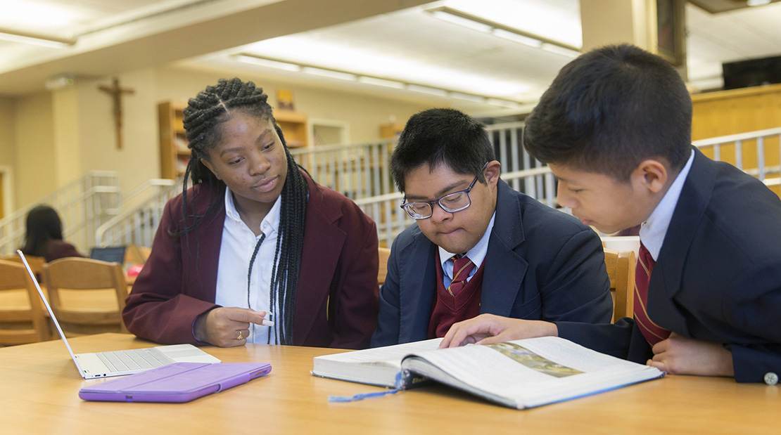 Raymond Tetschner, center, studied with fellow students in 2018 at Bishop McNamara High School in Forestville, Md. He is the first student to be a part of the school’s new St. Andre Program, designed to support students with intellectual disabilities in an inclusive setting.