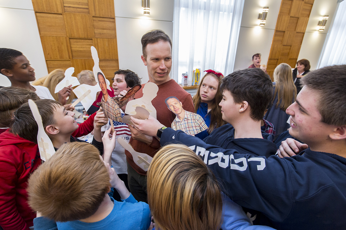 Students at All Saints Academy swarmed sixth-grade teacher Thomas Koehler for autographs Feb. 22 during a going-away party. Koehler, who will be serving for a year with the U.S. Navy in Djibouti, signed many of the cutouts that bore his image.