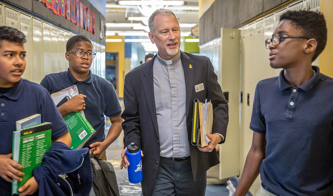Deacon James Griffard talked with Loyola Academy students Josh Lima-Lopez, DeAndre Baylerk and Elijah Merriweather in the hallway at the school May 9. The Next Chapter program, offered by Saint Louis University’s Office of Mission and Identity, helped Deacon Griffard discern what to do after his civil retirement. He took a part-time position teaching religion and providing social work support at Loyola Academy.