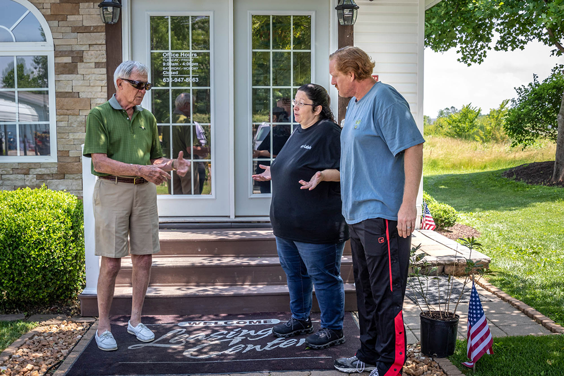 Dr. Tom Schneider, left, from the Society of St. Vincent de Paul talked with Patricia and Frank Goris as Schneider helped them at the Deerfield Village Mobile Home Park in St. Charles June 18. The Society will help the family with some bills and repair costs.