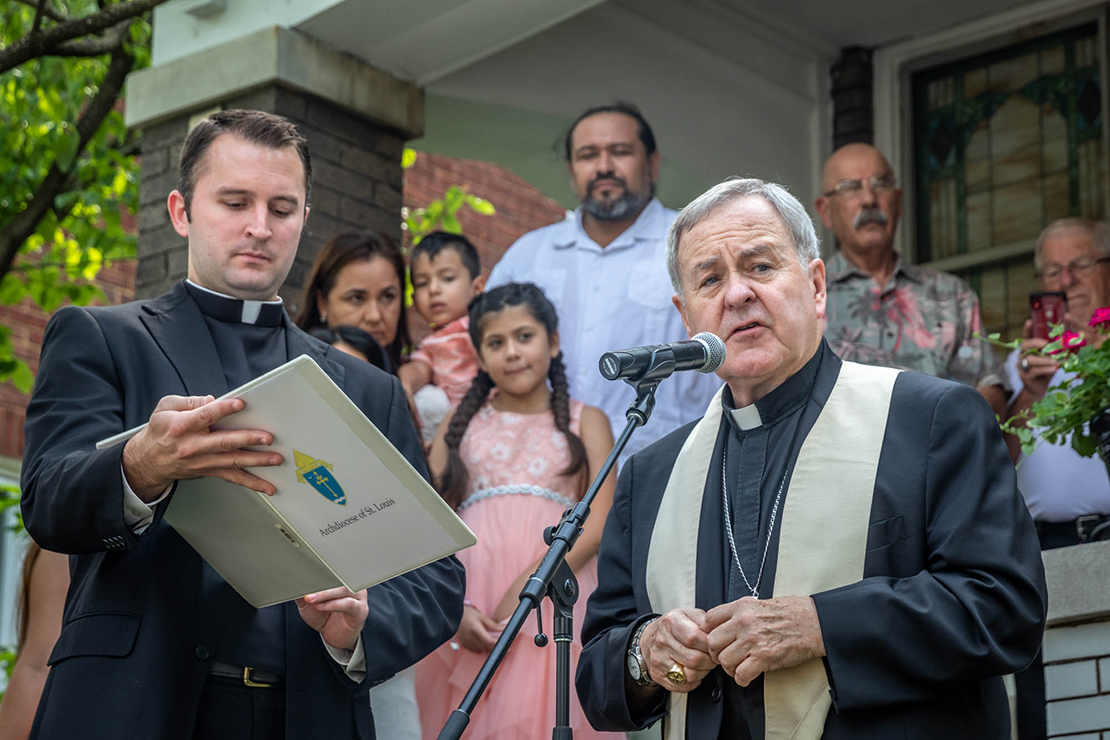 Archbishop Robert J. Carlson blessed the St. Joseph Housing Initiative’s first house in St. Louis June 27. The Estrada-Mendoza family, future homeowners, stood behind Archbishop Carlson on the steps of the house.