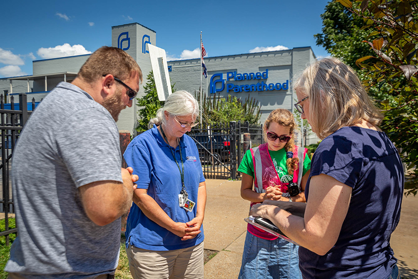 Coalition for Life volunteer sidewalk counselors, from left, Brad Baumgarten, MaryAnn Seelye, Ellen Prize and Denise Brockman prayed as they changed shifts outside Planned Parenthood in St. Louis July 30.