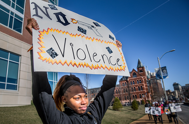 Shayla Davis held a "No violence" sign as protesters from Cardinal Ritter College Preparatory High School walked along Grand Boulevard on March 14. 