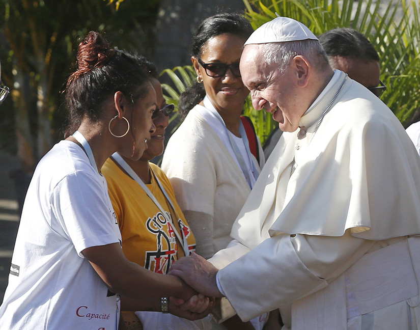 Pope Francis greeted a young woman as he visited the Shrine of Blessed Jacques-Desire Laval, the "apostle of Mauritius," in Port Louis, Mauritius, Sept. 9.