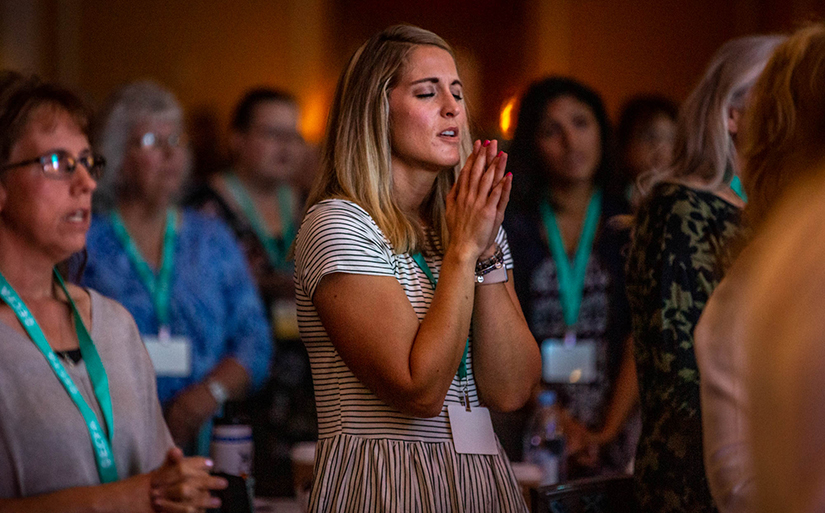 Lindsay Johnson, a speaker for abstinence training at anchor180.com from Farmington, N.M., prayed during praise and worship at CareNet’s conference for pregnancy resource center workers at Union Station in St. Louis Sept. 4. CareNet is a network of affiliated pregnancy care centers across North America.