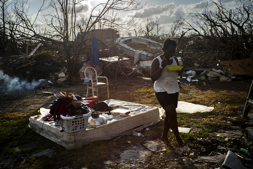 Tereha Davis, 45, walked among the remains of her shattered belongings, in the aftermath of Hurricane Dorian, in McLean’s Town, Grand Bahama, Bahamas, Sept. 11. She and others said they had not seen any government officials and have only received food and water from nonprofit organizations.