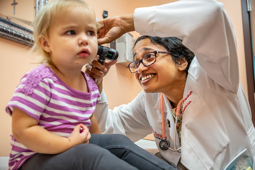 Dr. Elizabeth Abraham gave an exam to two-year-old Delaney Givens at St. Teresa Pediatrics in Shrewsbury on Sept. 24. As a Catholic physician, Abraham sees that it’s her “responsibility to be as scientifically minded as possible.”