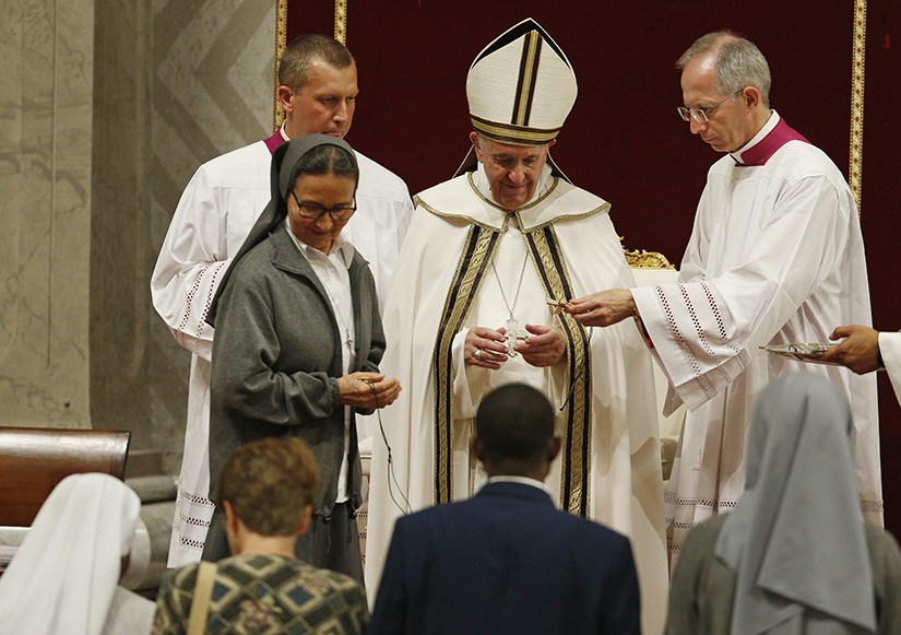 Pope Francis presented crosses to new missionaries at a prayer vigil opening a month dedicated to missionaries, in St. Peter’s Basilica at the Vatican Oct. 1.
