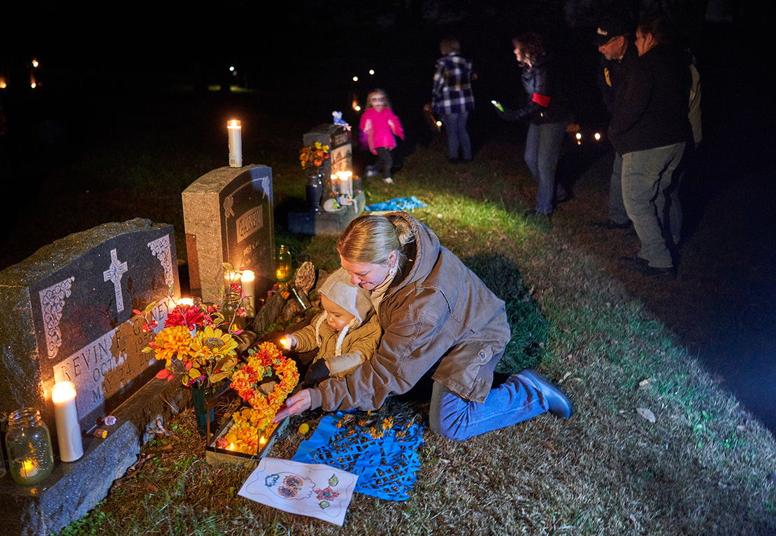 Laura Flamion and her family visited the gravesite of her father. Members and friends of the Our Lady Queen of Peace Church commemorate Dia de los Muertos at the church cemetery near House Springs on November 2.