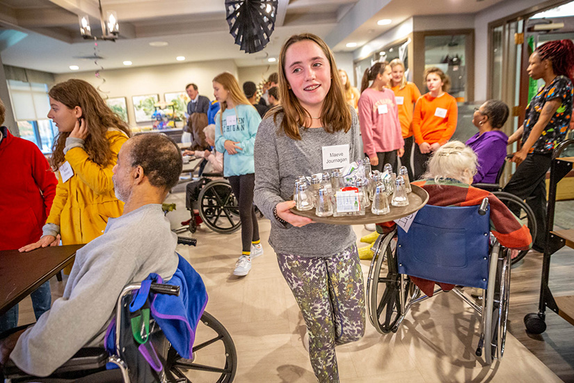 Maeve Journagan cleared tables as Christ the King School students visited patients Oct. 30 at Barnes-Jewish Extended Care in Clayton.