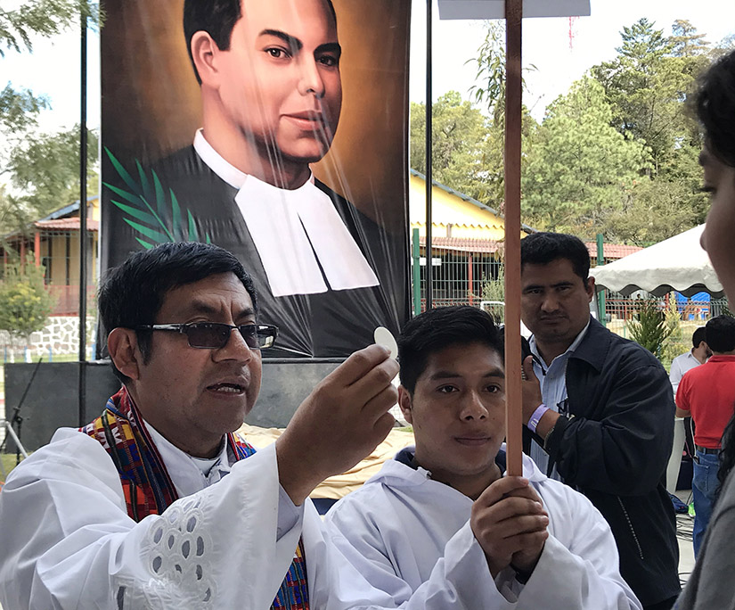 A clergyman distributed Communion during the beatification Mass of Blessed James Miller in Huehuetenango, Guatemala. Blessed Miller, a De La Salle Christian Brother, went through formation at La Salle Institute in Glencoe.