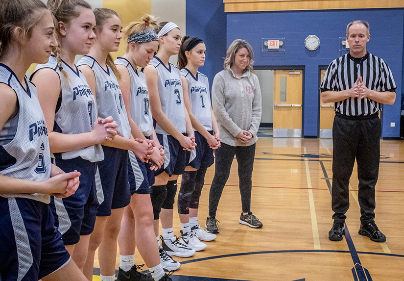 Referee John Diffley and players prayed before a eighth-grade girls basketball game between St. Peter Parish in Kirkwood and St. Paul Parish at St. Paul in Fenton Jan. 12.