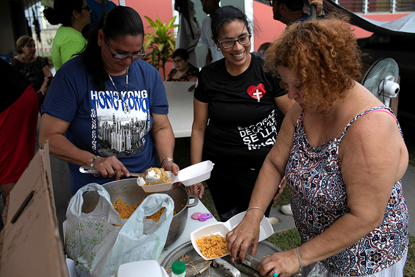 Women prepared free meals for earthquake victims in Guanica, Puerto, Rico, Jan. 8. Archbishop Roberto Gonzalez Nieves of San Juan toured the Diocese of Ponce, which suffered damage in the series of earthquakes that have hit Puerto Rico since Dec. 29.