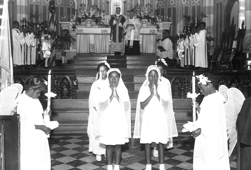 Children receive their First Communion at St. Nicholas Parish in St. Louis, in this undated photo. Founded in 1866, St. Nicholas was one of several parishes and church missions that ministered to African-American Catholics in the Archdiocese of St. Louis. In 1926, Archbishop John J. Glennon entrusted St. Nicholas to the care of the Society of the Divine Word, to serve as a mission church for the downtown district and to evangelize the African-American Catholics who had moved into the neighborhood.