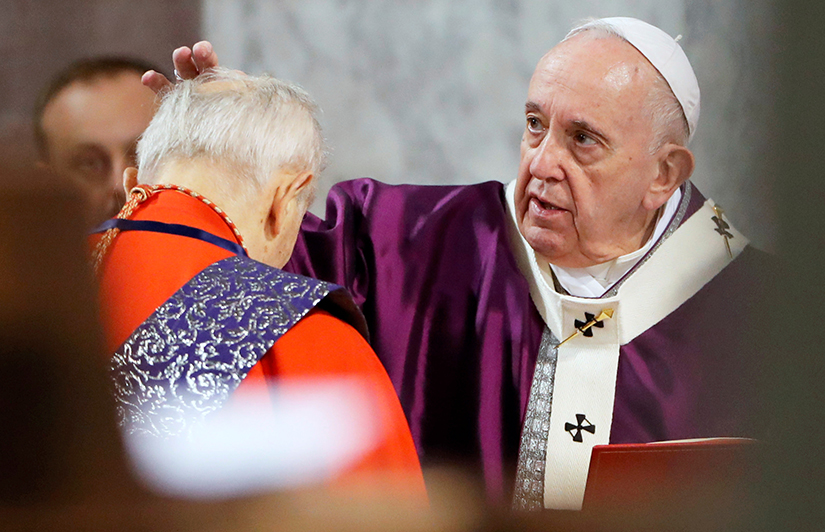 Pope Francis placed ashes on the head of a cardinal during Ash Wednesday Mass at Santa Sabina Basilica in Rome Feb. 26.