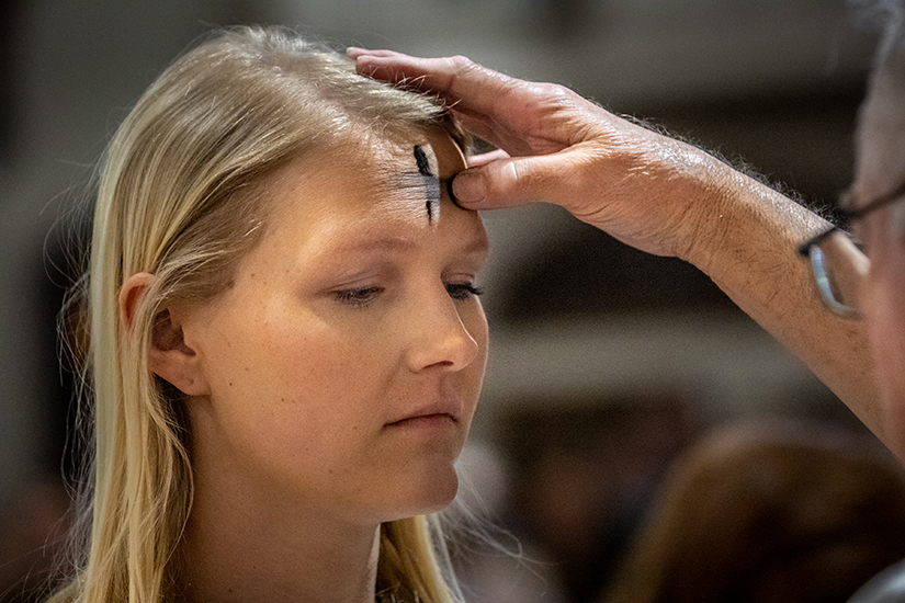Juliette Wolf, a parishioner at St. Raphael the Archangel, received ashes from Deacon Ed Grotpeter during noon Mass on Ash Wednesday at St. Joseph Parish in Clayton.