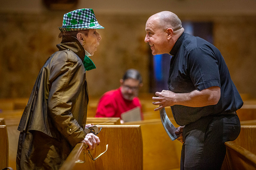 Father John Vien, right, informed parishioner Polly Walsh that the parish would not be celebrating daily Mass at Mary Queen of Peace Church in Webster Groves on March 17. Walsh previously experienced quarantine as a child when her father contracted smallpox.