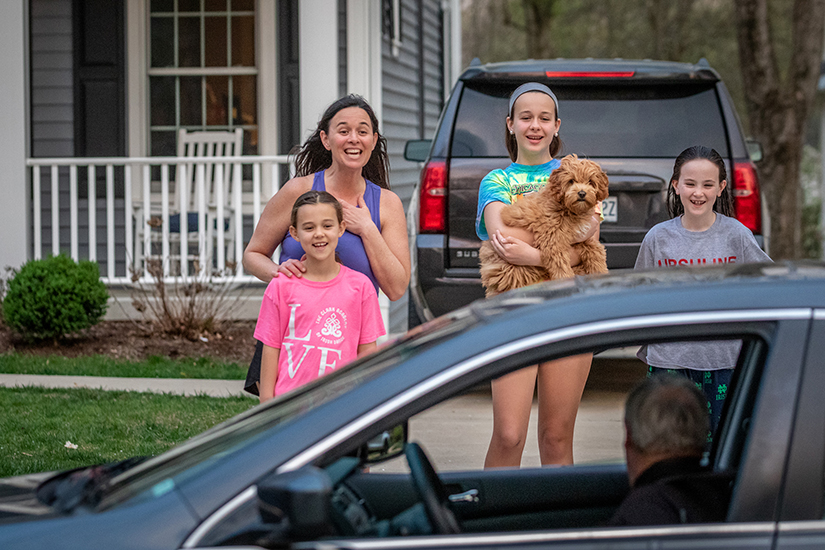 Msgr. Jack Costello, pastor of St. Peter Parish, visited parishioner Jeanie Kelly and her daughters Maeve, Annie and Caroline (and dog Lucy) from his car outside their home in Kirkwood on April 8. The girls all go to school at St. Peter in Kirkwood.