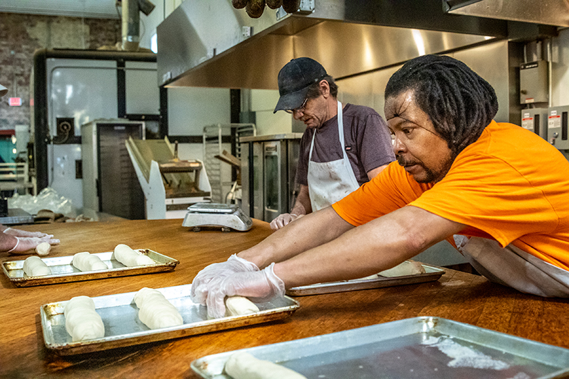 Bakers Kevin Turnbull, left, and Kevin Brefford made sourdough bread at Bridge Bread on April 22. Bridge Bread has been making bread for area food pantries after stay-at-home orders prevented the organization from selling bread as it had previously.