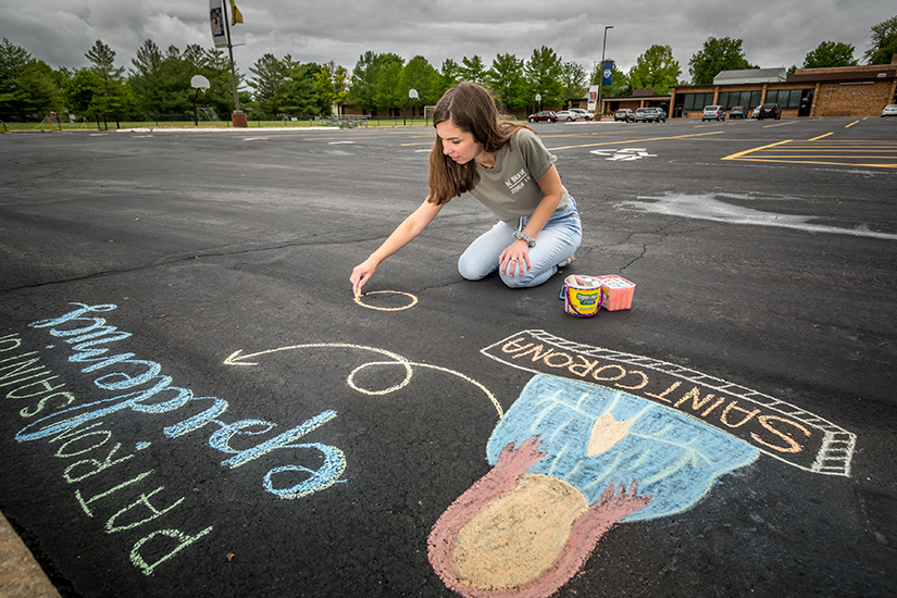 Jill Joeckel drew a chalk art design of St. Corona on the parking lot at St. Cletus Church in St. Charles on May 18. While much is unclear about St. Corona and her patronage and even existence, many Catholics have been seeking her intercession during the coronavirus (COVID-19) pandemic.