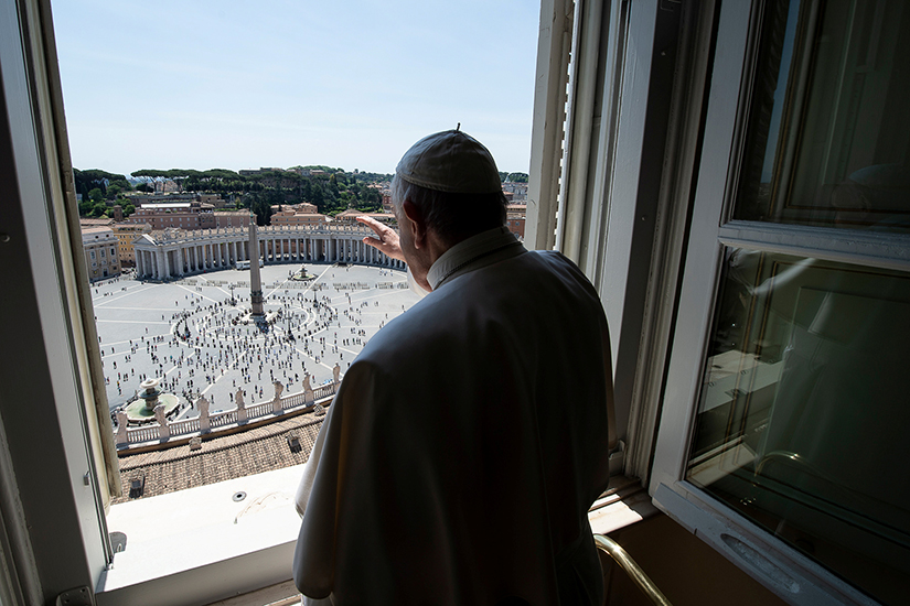 Pope Francis waved as he looked out on St. Peter’s Square after leading the “Regina Coeli” from his library in the Apostolic Palace at the Vatican May 24. It was the first time the public was allowed in the square after the easing of restrictions during the coronavirus pandemic.